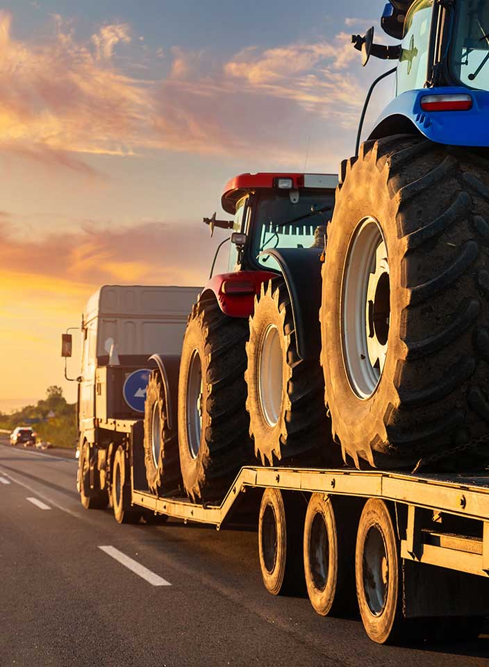 Trator e máquina agrícola transportada em estrada